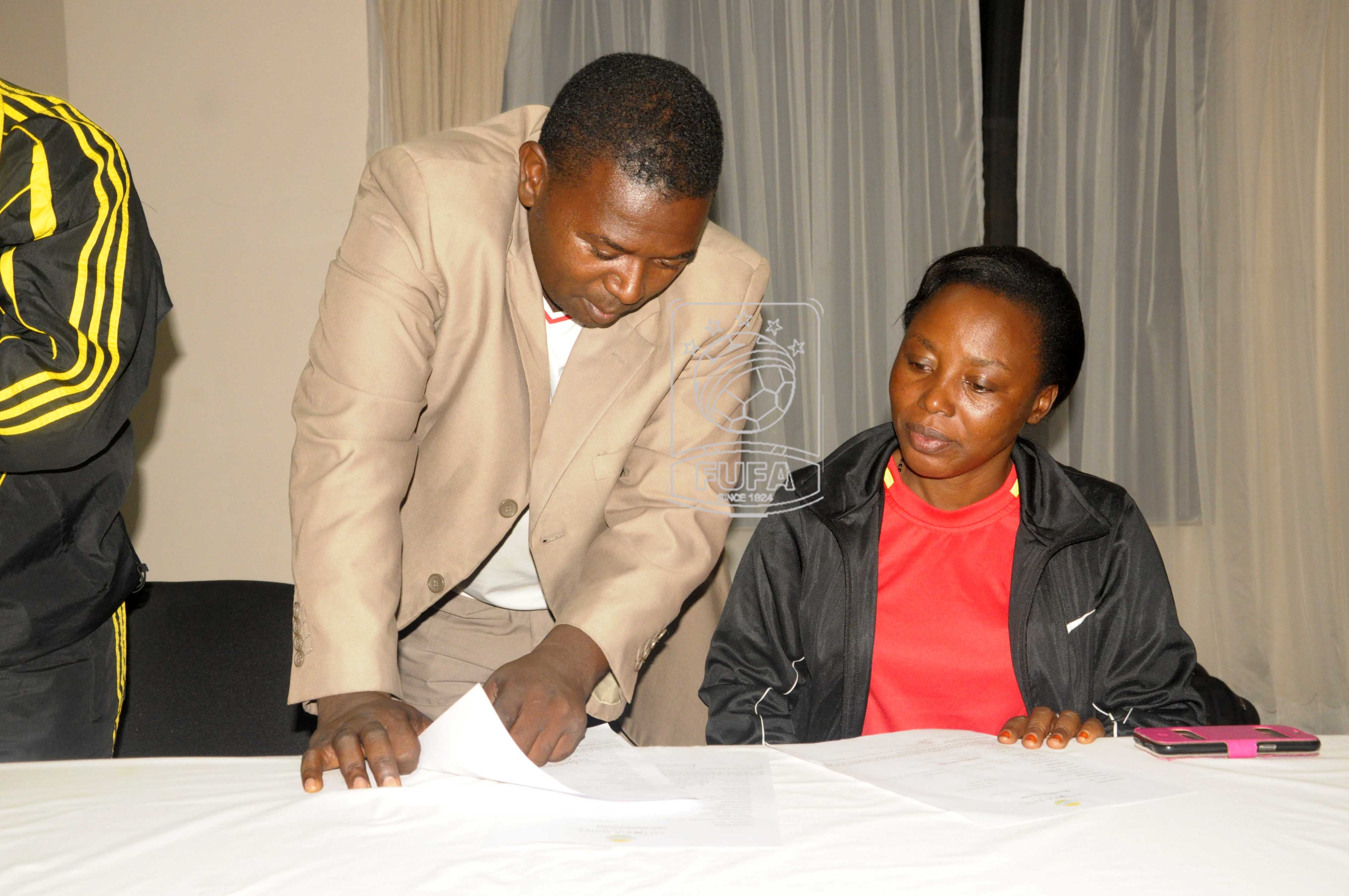 FUFA Executive member and leader of delegation Agne Mugena (right) consulting with women football delegate Ayub Khalifa on arrival in Kisumu.