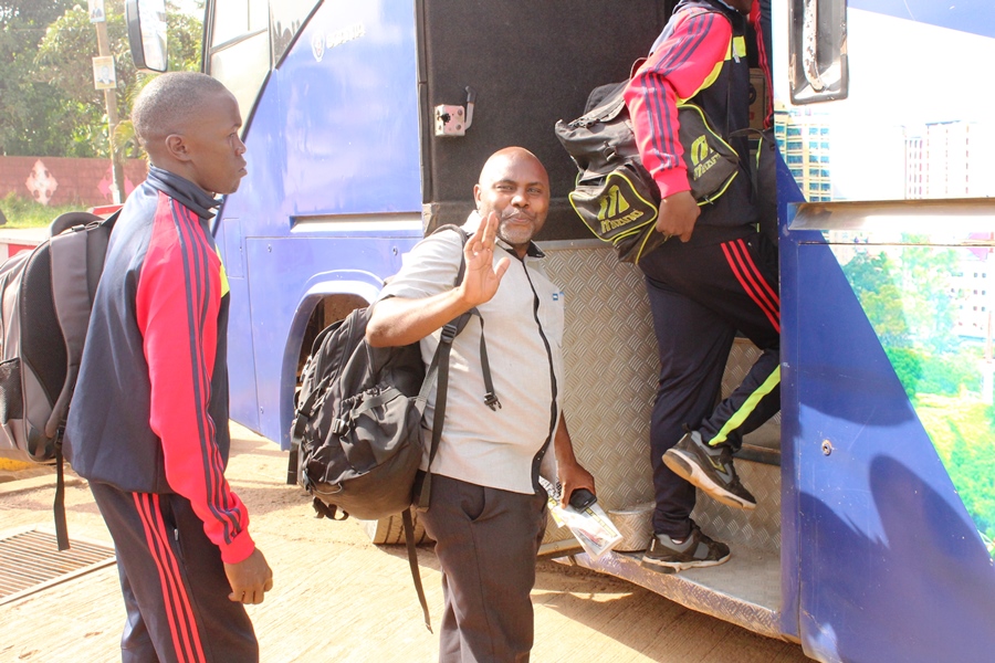 Beach Soccer Delegate Anthony Tumwesigye waves good bye as he gets to the team bus. Behind him is defender Geofrey Akabwai