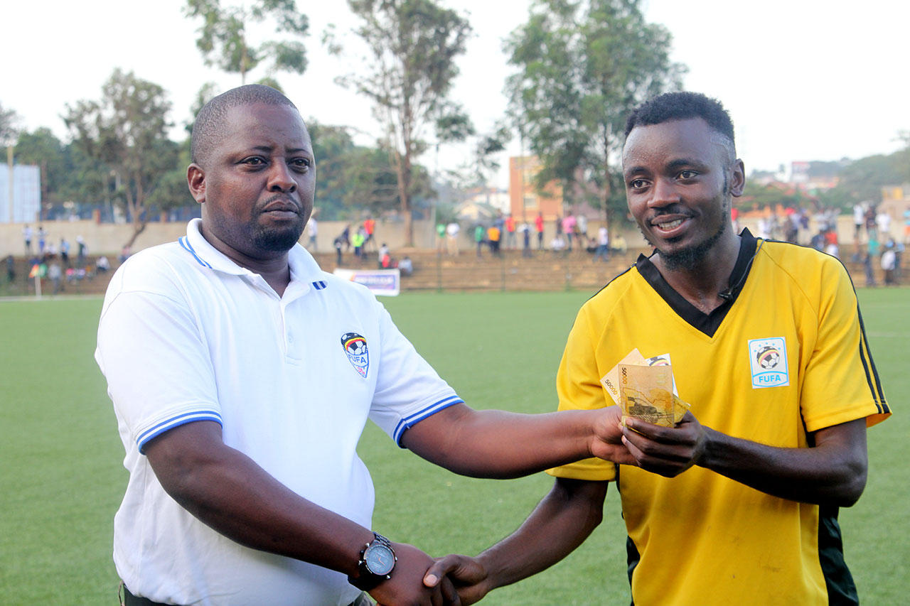 Muwada Mawejje of Bugisrecievs MoTM cash prize from the FUFA 2nd Vice President Darius Mugoye